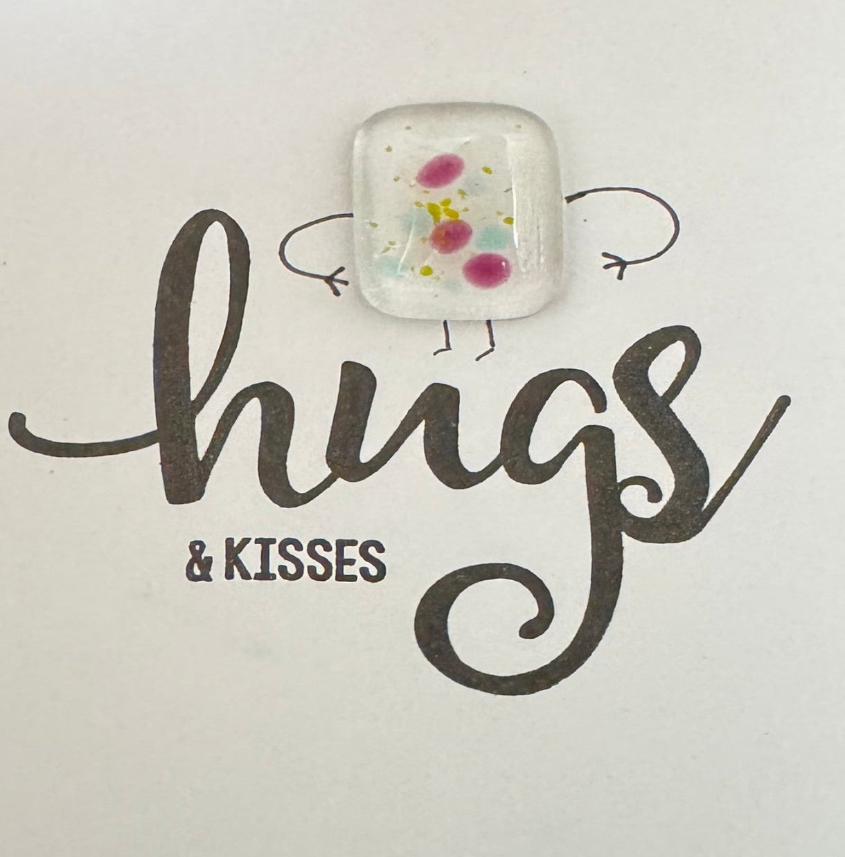 Card with a decorative fused glass body and 'hugs & kisses' text on a plain background